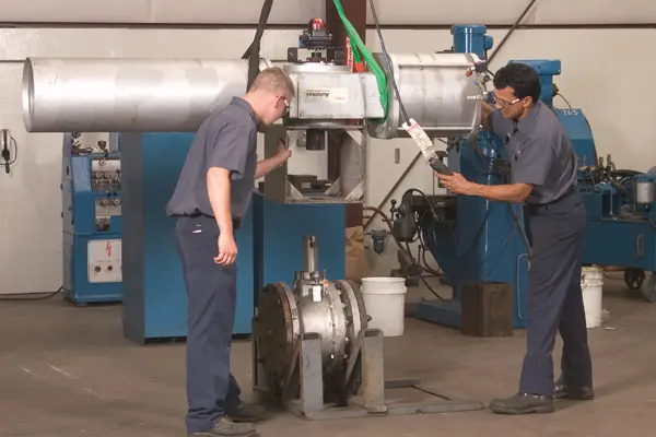 Two team members perform industrial valve maintenance